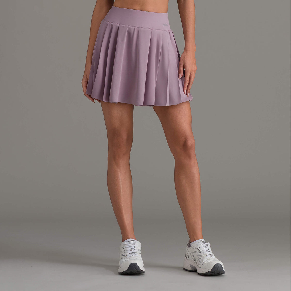Falda corta deportiva malva con pliegues tipo acordeón y cintura elástica
