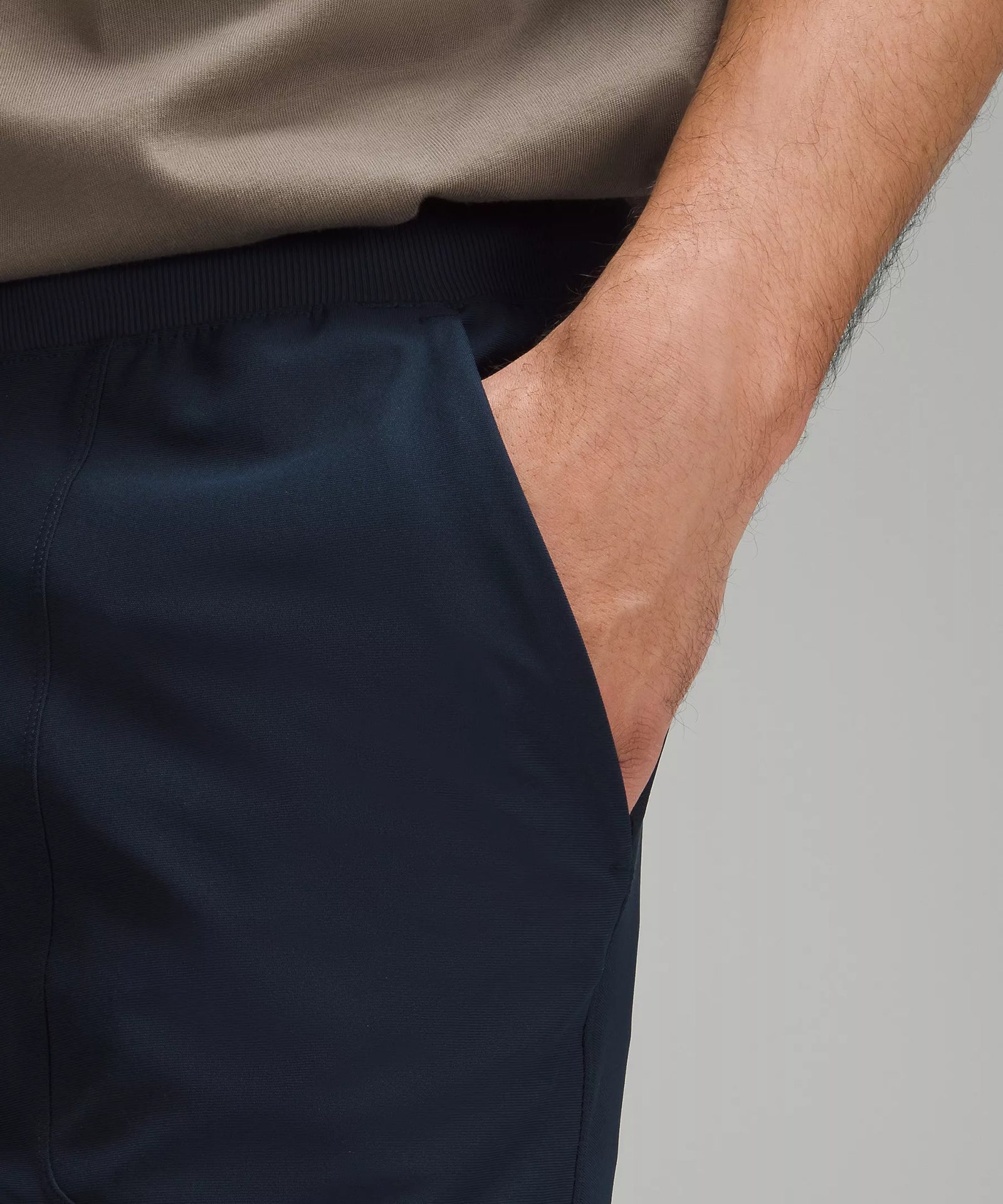 Pantalón con corte cónico de color azul, vista frontal al detalle del bolsillo.