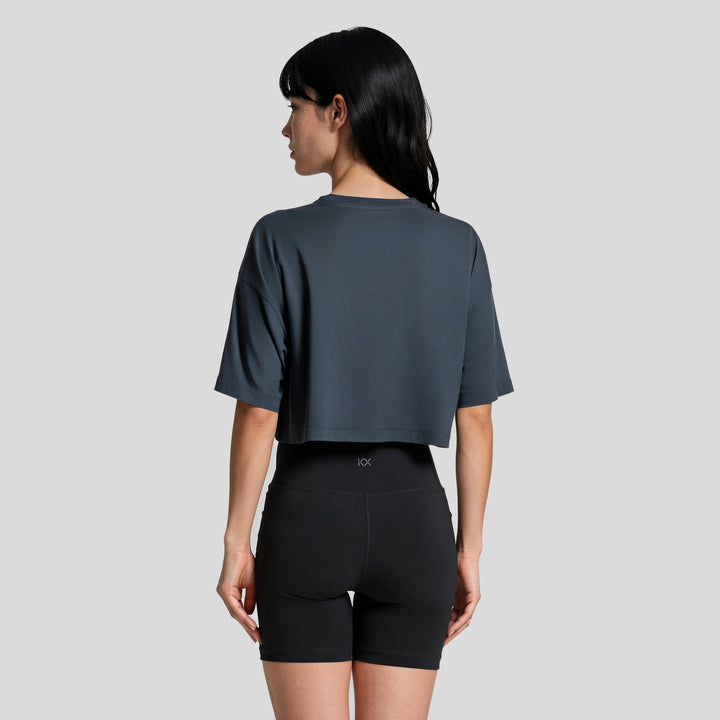 Conjunto mujer con playera corta azul marino y short ajustado negro, vista trasera