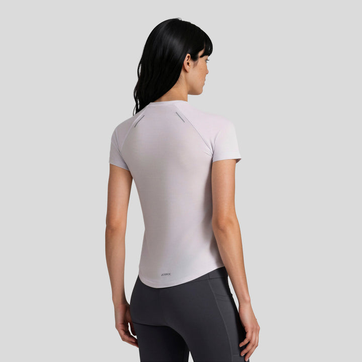 Playera deportiva de mujer lila, vista trasera con manga corta y cuello redondo.