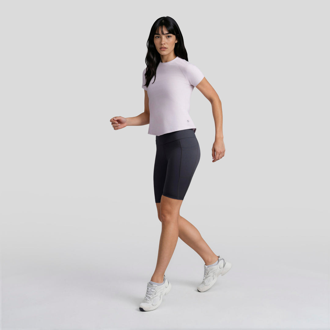 Playera deportiva de mujer lila con manga corta y cuello redondo, vista 3/4.