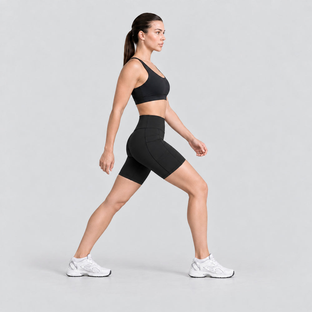 Conjunto deportivo negro en vista lateral: top sin mangas y biker de tiro alto