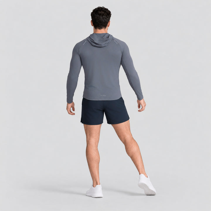 Conjunto deportivo azul: playera de manga larga con capucha y short ligero.