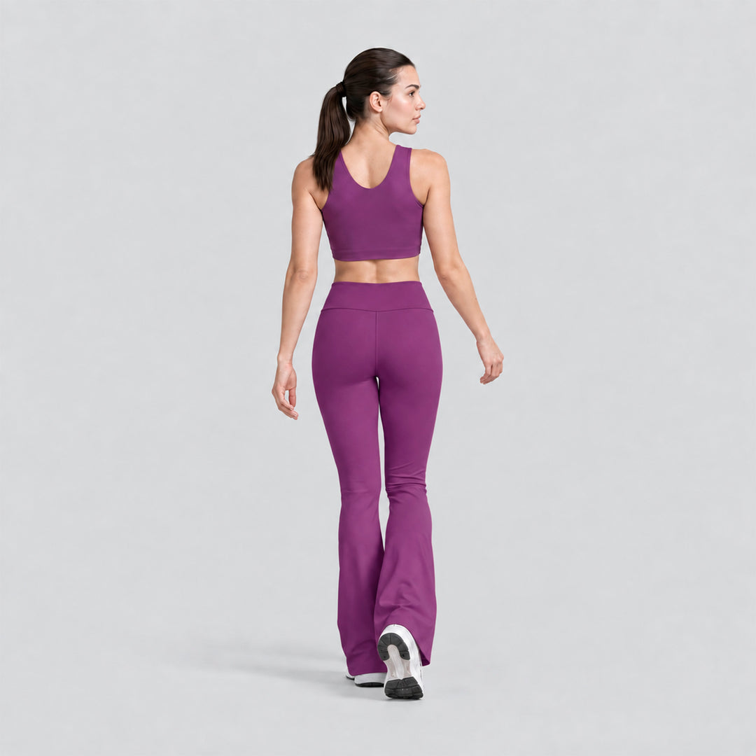Vista trasera: conjunto deportivo morado con top cropped sin mangas y legging flare tiro alto