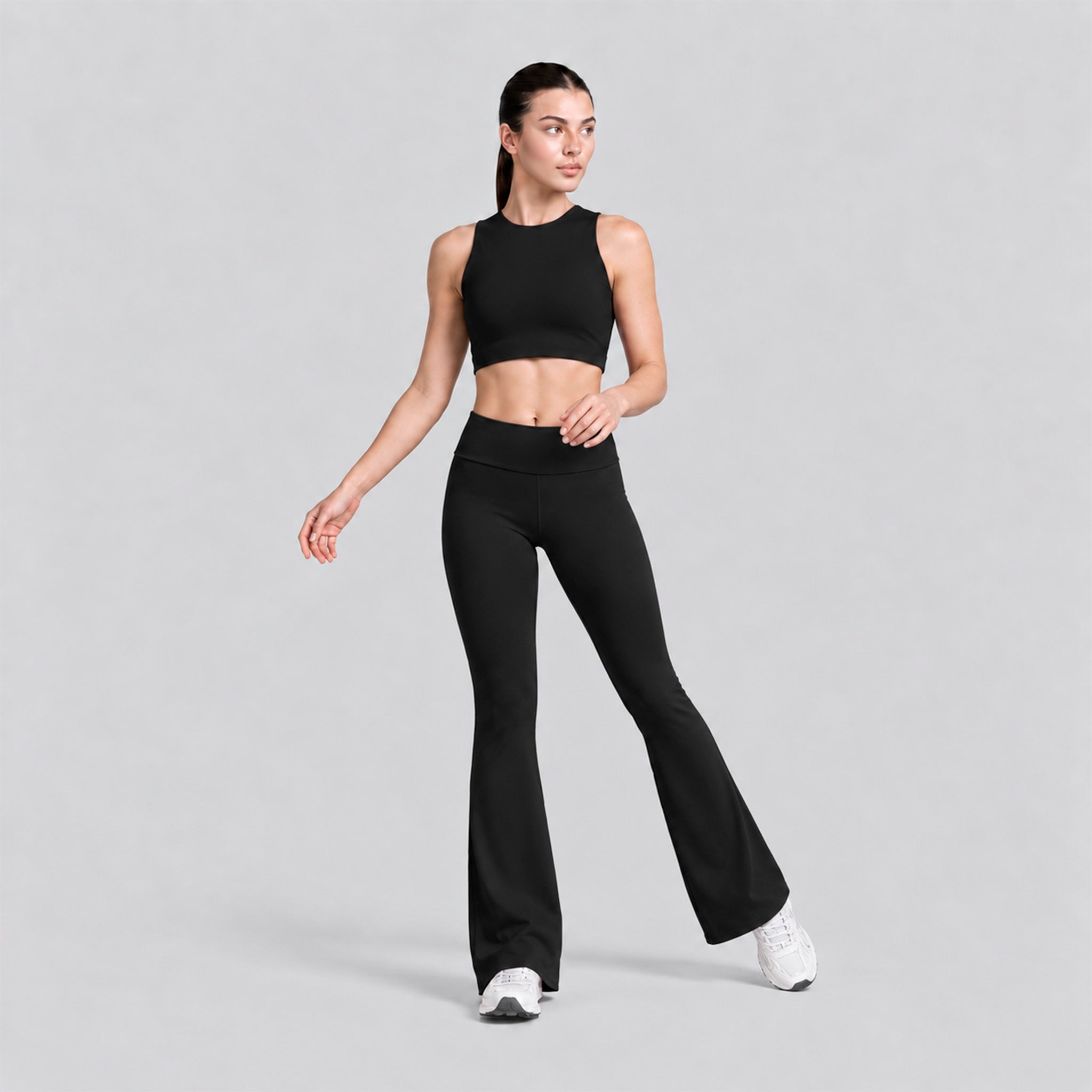 Conjunto deportivo negro: top cropped sin mangas y legging flare tiro alto.