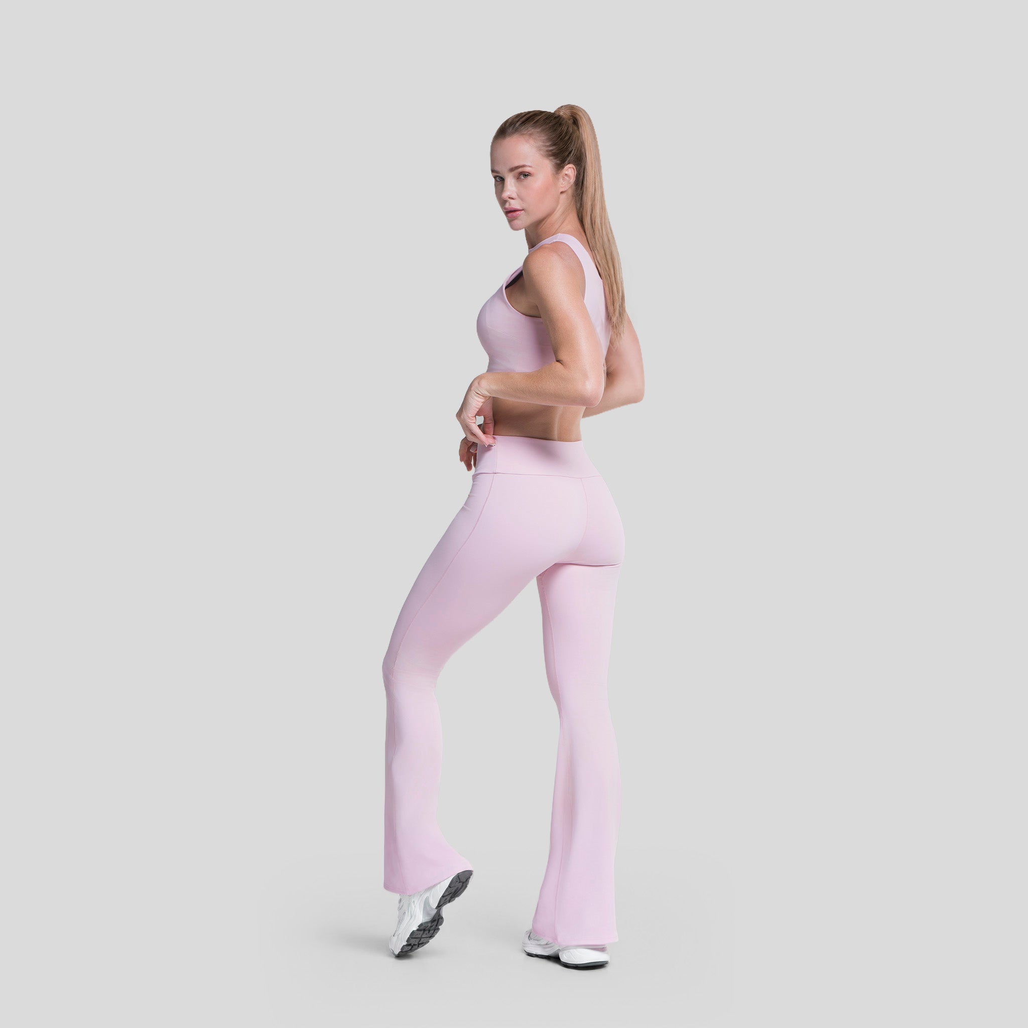 Conjunto deportivo lila: top cropped sin mangas y legging flare de tiro alto.