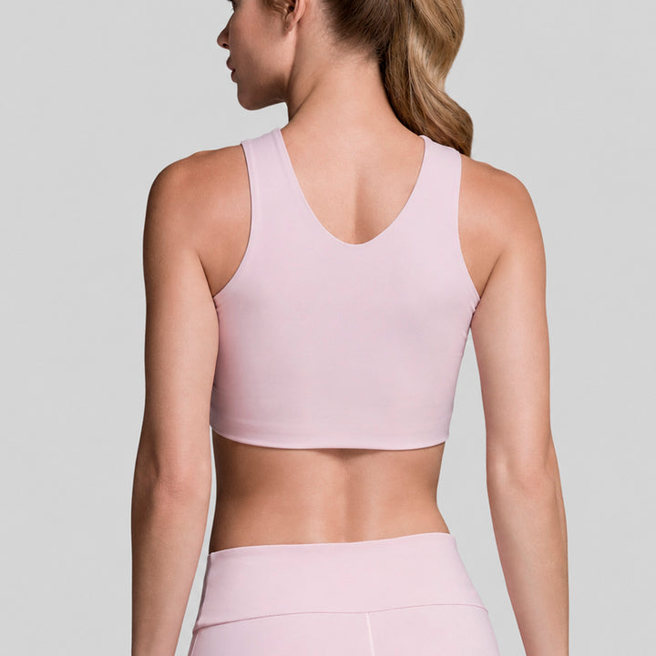 Top cropped lila sin mangas y cinturilla de legging flare de tiro alto, vista cercana.