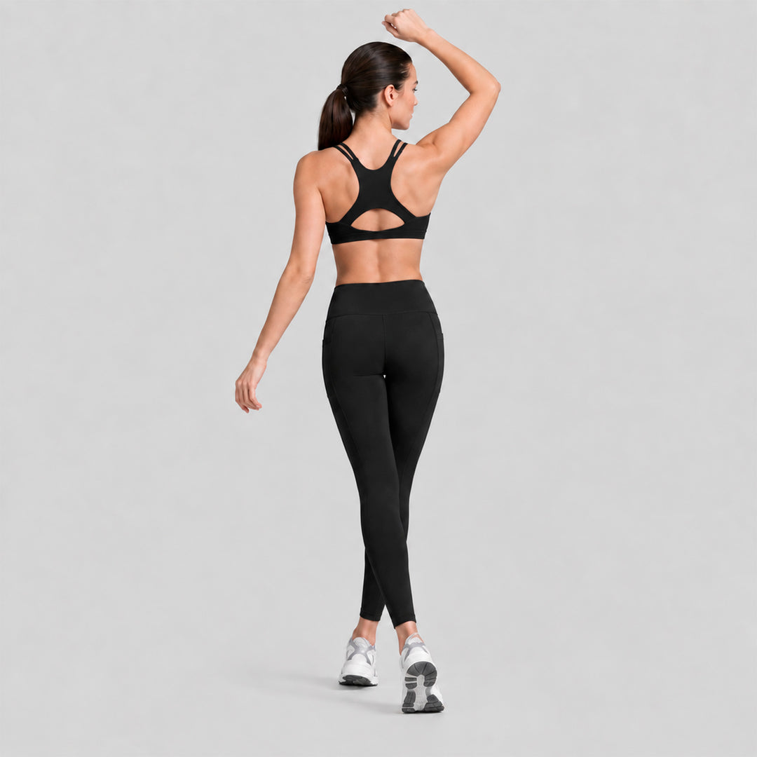 Conjunto deportivo negro, top cruzado en la espalda y legging tiro alto