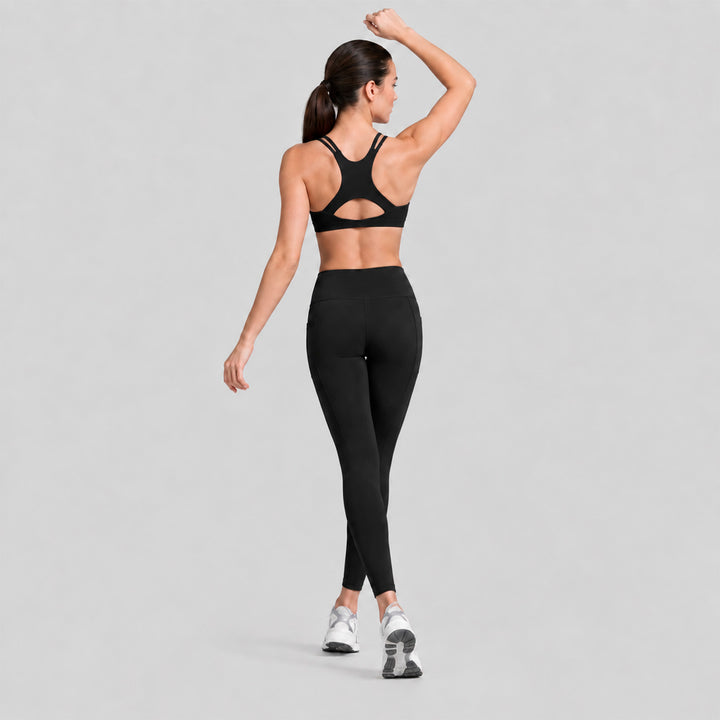 Conjunto deportivo negro, top cruzado en la espalda y legging tiro alto