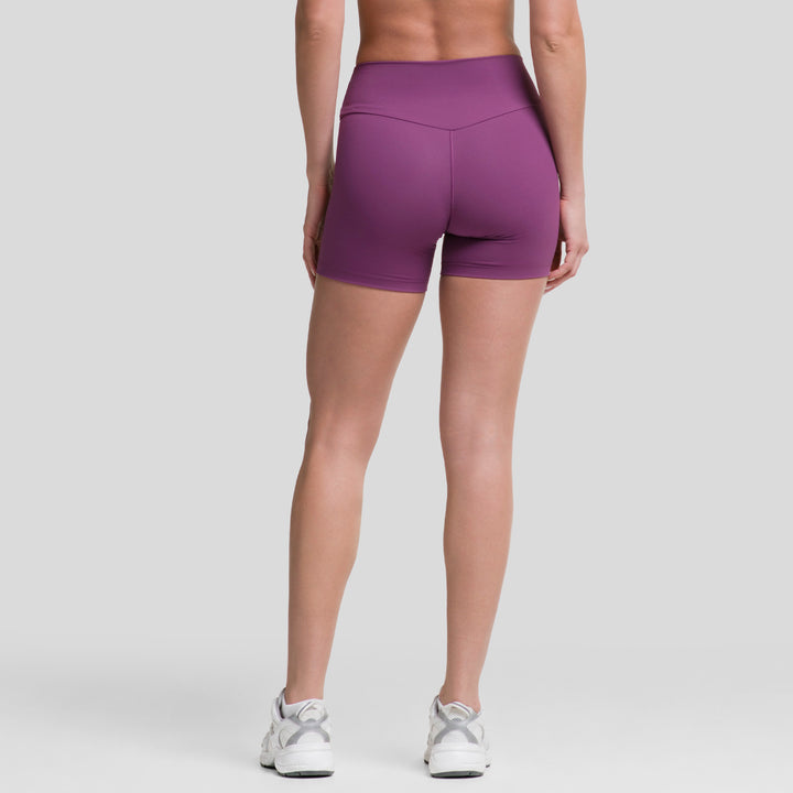 Short biker mujer morado, vista trasera con tiro alto y costura central visible.