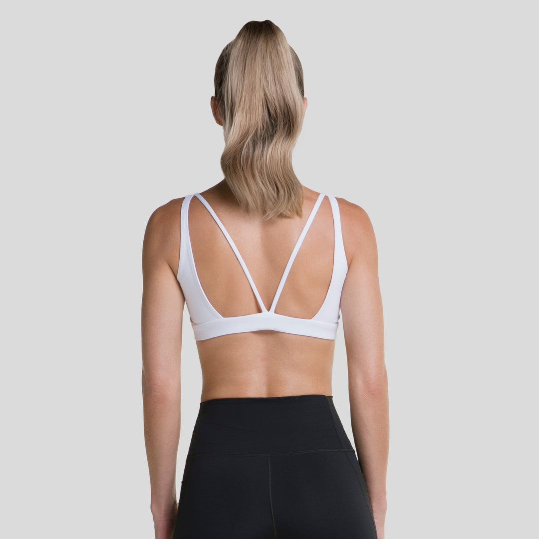 Top deportivo mujer blanco con espalda cruzada en X y tirantes visibles