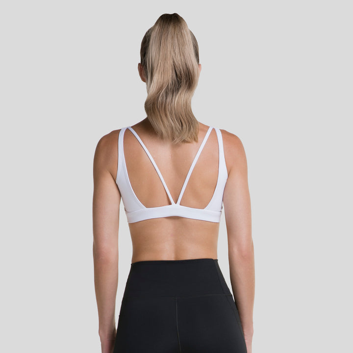 Top deportivo mujer blanco con espalda cruzada en X y tirantes visibles